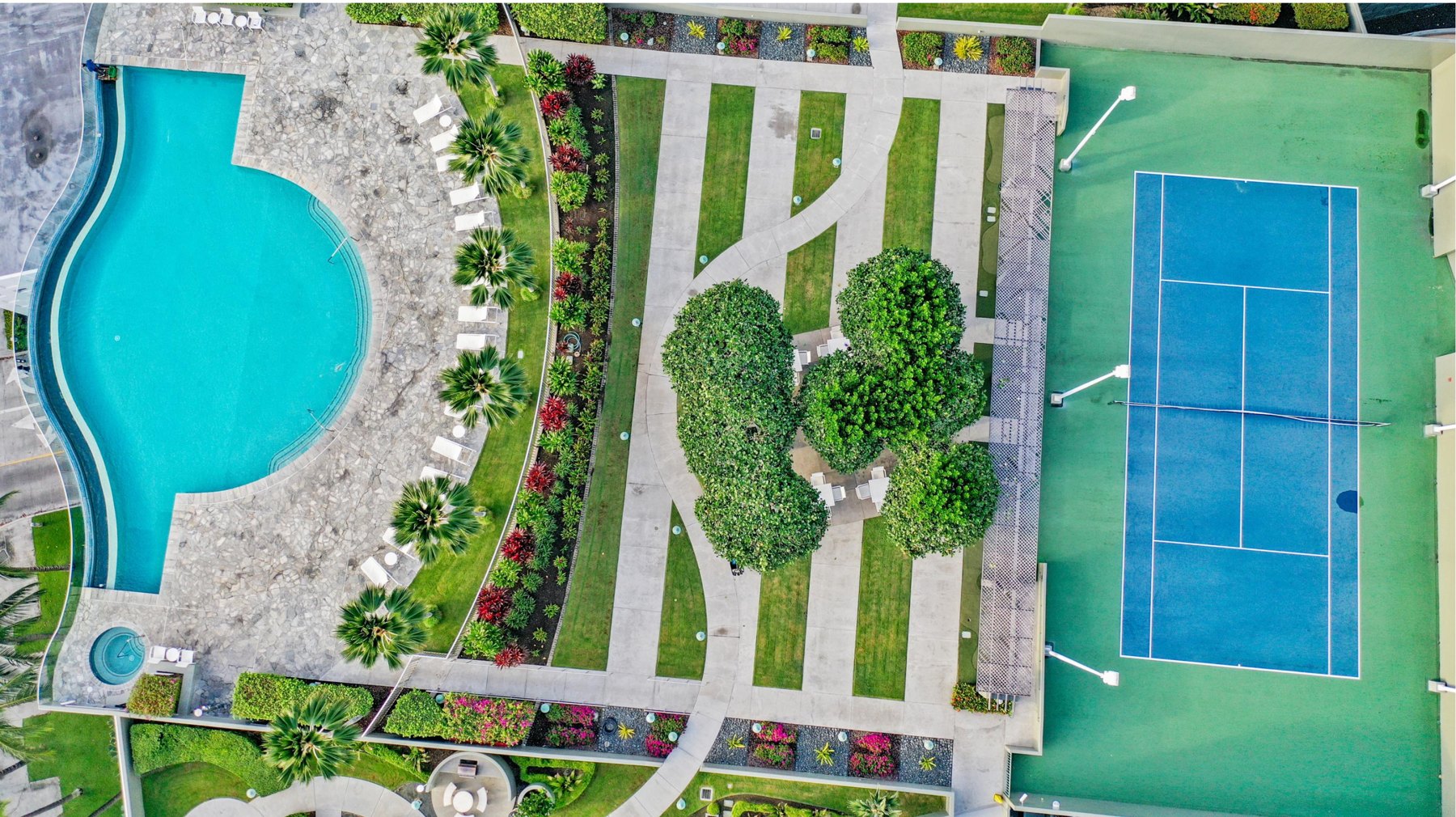 Aerial view of a planned resort with pool, gardens and tennis court